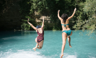 A couple jumping into a pool
